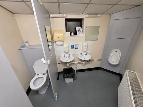 The cubicle, washbasins and urinal in the upstairs men's toilets