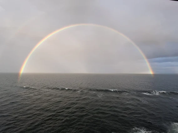 A double rainbow over open water.