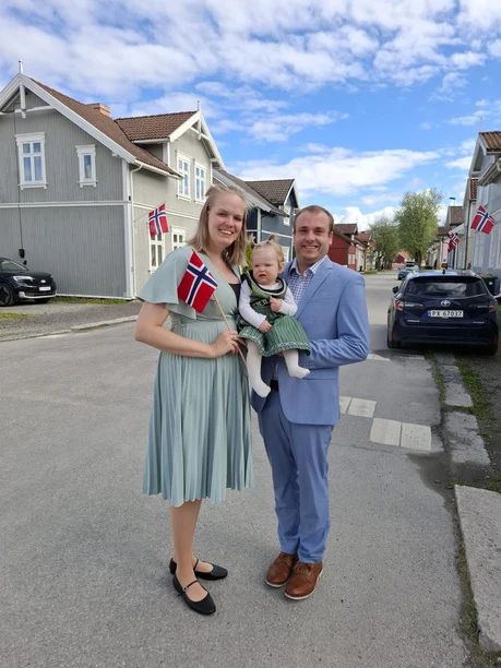 Ben, Leonieke and Elianne together on a street decorated with Norwegian flags.