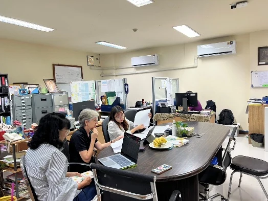 Judy and colleagues working around a table in the SDSU office.
