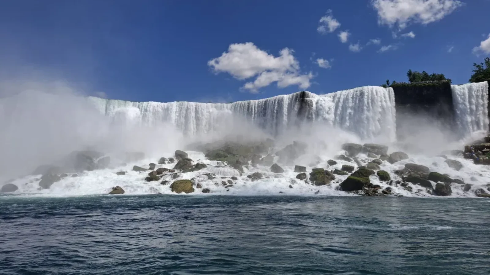 Waterfall cascading over rocks under a blue sky, from the Salmons family’s Youth Impact newsletter.