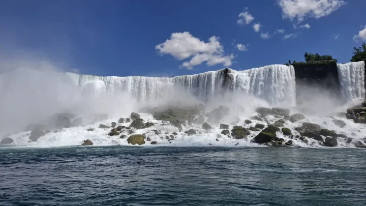 Waterfall cascading over rocks under a blue sky, from the Salmons family’s Youth Impact newsletter.