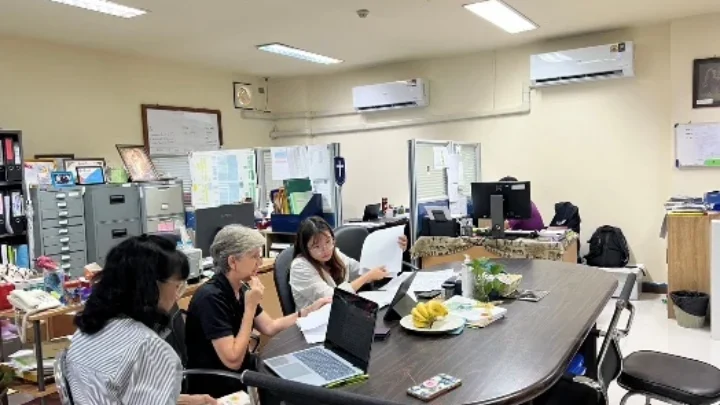 Judy and colleagues working around a table in the SDSU office.